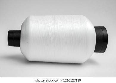 white sewing machine thread over white background 