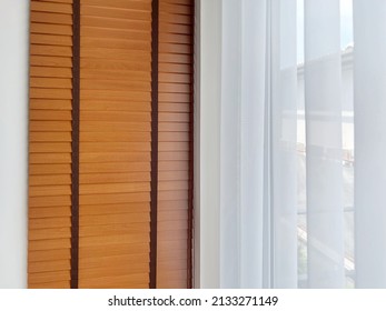 White Sheer Curtains With Translucent Fabric And Wooden Blinds Hanging On Window.