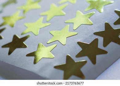  A White Sheet Of Gold Star Stickers Lays On A White Poster Board In Anticipation Of Kids Going Back To School In August.