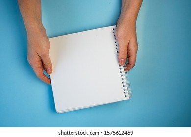 white sheet of Notepad in two hands, copyspace