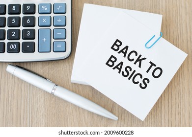 White Sheets Of Paper For Notes, On One Sheet The Inscription BACK TO BASICS On A Wooden Background Next To A Pen And A Calculator
