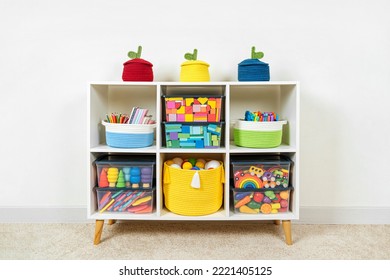 White shelving with rainbow wooden toys and colorful storage baskets and boxs. Interior design. Organizing and storage ideas in nursery. 