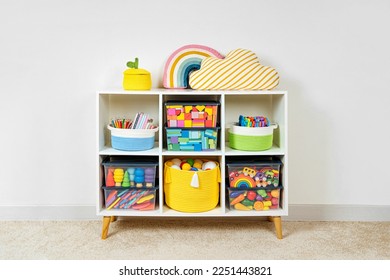 White shelving with rainbow wooden toys and colorful storage baskets and boxs. Interior design. Organizing and storage ideas in nursery.  - Shutterstock ID 2251443821