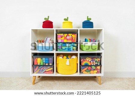 White shelving with rainbow wooden toys and colorful storage baskets and boxs. Interior design. Organizing and storage ideas in nursery. 