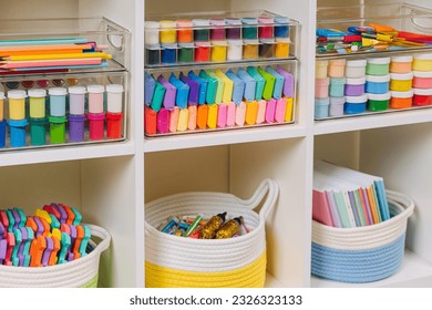 White shelving with various material for creativity and kids art activity. Stationery and supplies for drawing and craft. Organizing and storage in craft room.   - Powered by Shutterstock