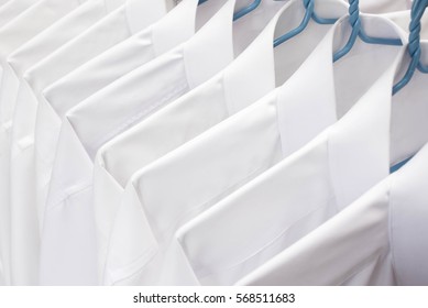 White Shirts Hanging On Rack In A Row, Selective Focus	