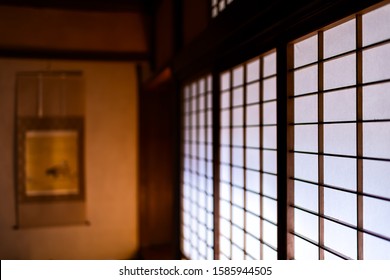 White shoji sliding paper doors closed in traditional japanese house or ryokan pattern and blurry background of tokonoma scroll