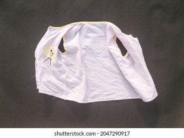 White Shrunken Baby Clothes On Floor After Laundry Washing. Due To Laundry The Cotton Fibers Shrink Than Normal Size. Table Top View. Copy Space For Text.