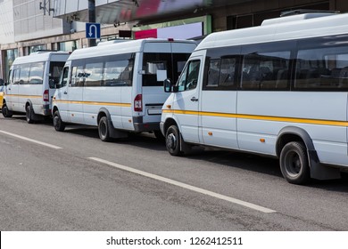 White Shuttle Buses At The Bus Stop