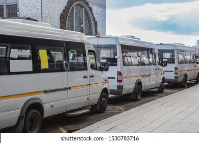 White Shuttle Buses At The Bus Stop