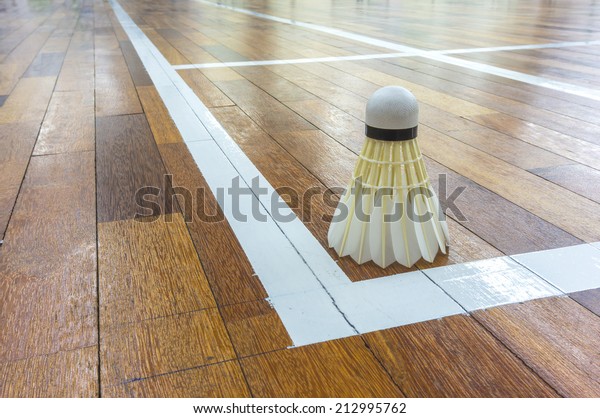 White\
shuttlecock close up with timber\
flooring