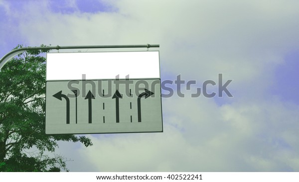 White sign board, Turn left, Turn
Right, Go straight sign with green tree on blue sky
background