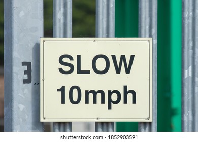 White Sign limiting speed to Slow 10 mph on metal gate