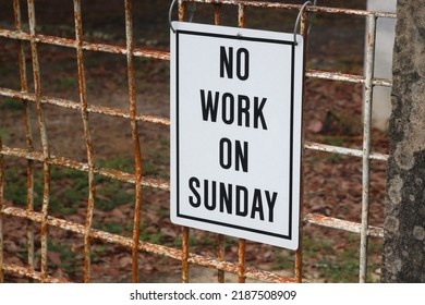 White Sign on Wire Fence announcing No Work on Sunday.