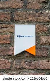 A White Sign With An Orange Highlight On A Brick Wall Indicating In Dutch That This Building Is National Monument (Rijksmonument),