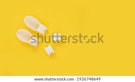 White silicone finger divider on a yellow background. Prevention and treatment of hallux valgus