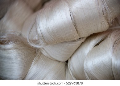 White silk fibers close-up. Illustration about silk production technology.