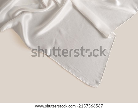 White silk scarf on hand isolated high quality image on beige background ideal for creating mockup for presentation own textile design and seamless pattern