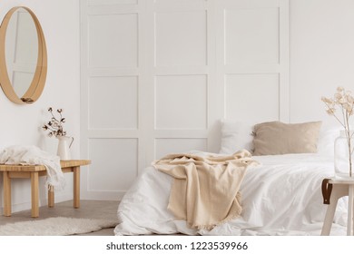 White simple bedroom design with mirror, dresser and comfortable bed with white sheets, real photo - Powered by Shutterstock