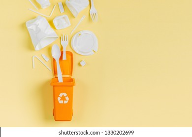 White Single Use Plastic In Garbage Bin On  Yellow Background.
Concept Of Recycling Plastic. Flat Lay, Top View