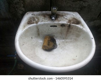 The White Sink In The Car Garage That Has Been Used For A Long Time Is Extremely Dirty.