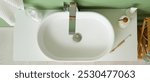 White sink, cosmetics and toothbrush on stand in bathroom, top view