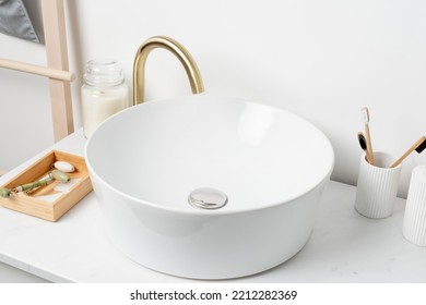 White Sink On Marble Counter With A Round Mirror Hanging Above It. Bathroom Interior. Copy Space