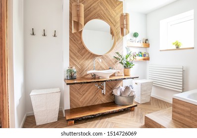 White sink on wood counter with a round mirror hanging above it. Bathroom interior. - Shutterstock ID 1514726069