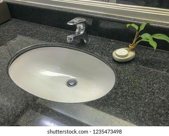 white sinks and soap in public toilet - Shutterstock ID 1235473498