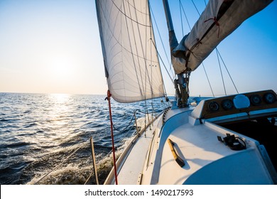 White sloop rigged yacht sailing on a clear day. Close-up of the deck, bow, mast, sails. Brittany, France. Transportation, sport, recreation, leisure activity, regatta, travel, vacations, adventure