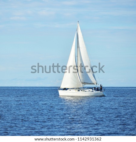 White sloop rigged yacht sailing in the Baltic sea at sunset. Clear sky after the storm, soft sunlight. Transportation, travel, cruise, sport, recreation, leisure activity, lifestyle, family
