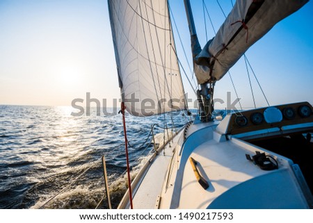 White sloop rigged yacht sailing on a clear day. Close-up of the deck, bow, mast, sails. Brittany, France. Transportation, sport, recreation, leisure activity, regatta, travel, vacations, adventure