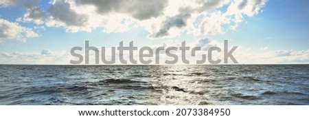 White sloop rigged yacht sailing at sunset. Clear sky after the storm. View from the deck to the bow, mast, sails. Transportation, travel, cruise, sport, recreation, leisure activity, racing, regatta