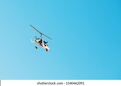 White small double gyroplane autogyro without a cabin against the blue sky. Air tours for tourists.