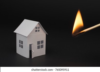 White Small House On Blurred Dark Background, Close Up, Selective Focus Fire Insurance And Real Estate Concept  