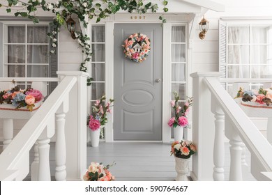 White Small Wooden House With Gray Door. Spring Flower Decoration