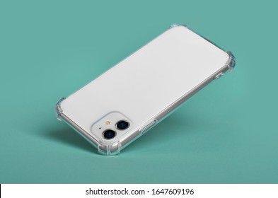 White Smart Phone In Clear Silicone Case Falls Down, Back View. IPhone 11 Case Mockup Isolated On Green Background IPhone 12