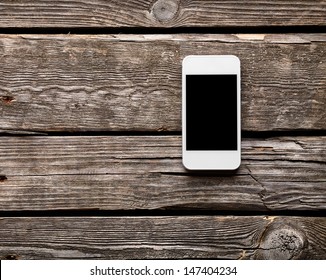 White Smart Phone With Isolated Screen On Old Wooden Desk.