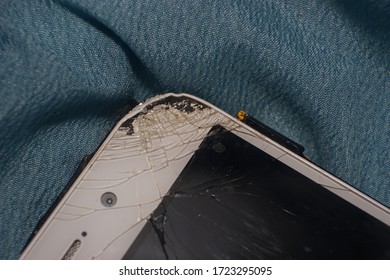 A White Smartphone With Cracked LCD Screen.