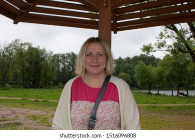 White smiling woman 42 years old in casual clothes in a Park on a summer day