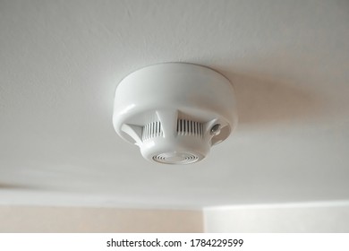 White smoke detector on the ceiling close-up