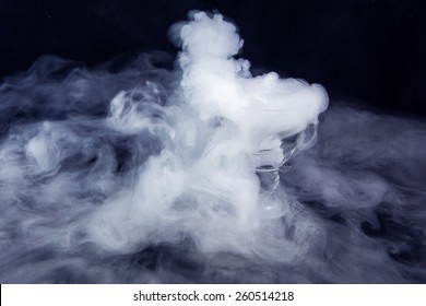 White Smoke In Glass With The Effect Of Dry Ice On Dark Blue Background