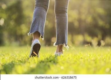 white sneaker jeans walking on green grass with sunset light - Shutterstock ID 626318675