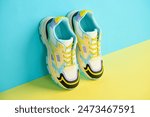 White sneakers with colored accents on bright background, Pair of fashionable sport shoes with colorful backdrop. Studio shot of shoes for shop advertisement, creative minimalist style