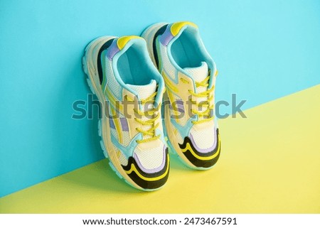 White sneakers with colored accents on bright background, Pair of fashionable sport shoes with colorful backdrop. Studio shot of shoes for shop advertisement, creative minimalist style