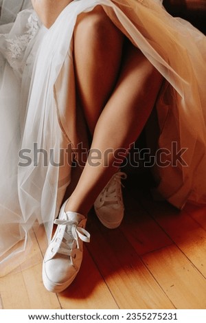 white sneakers on the feet of the bridegroom. Preparing the bride for the ceremony. Comfortable shoes for a wedding. White sneakers.