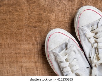 White Sneakers Shoes On Wooden Background With Copy Space. Top View Image.