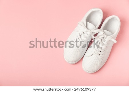 White sneakers, trainers on bright colored background. Unisex casual sports shoes. Top view. Space for text. Copy space.Stylish sport shoes. Trendy footwear