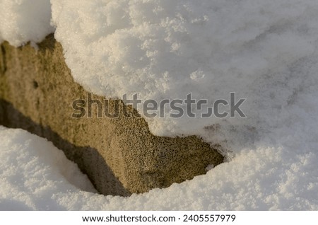 white snow on porous aerated concrete brick