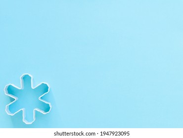 White Snowflake Cookie Cutter On A Blue Background, Space For Text, Christmas And Winter Theme 